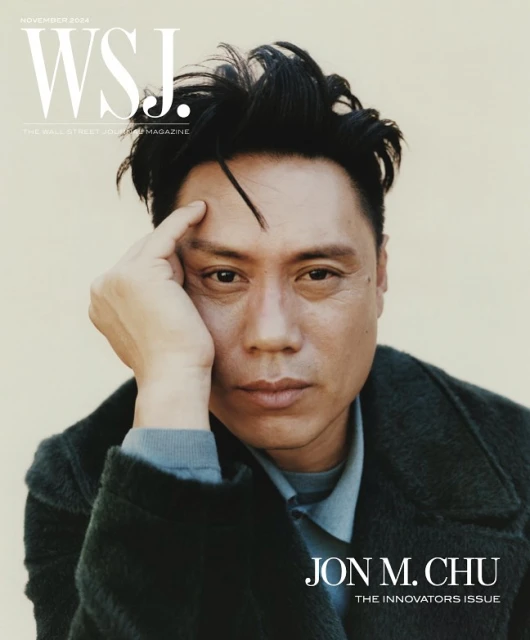 WSJ cover featuring Jon M. Chu looking pensively at the camera with dark hair, wearing a blue collared shirt and a dark green coat.