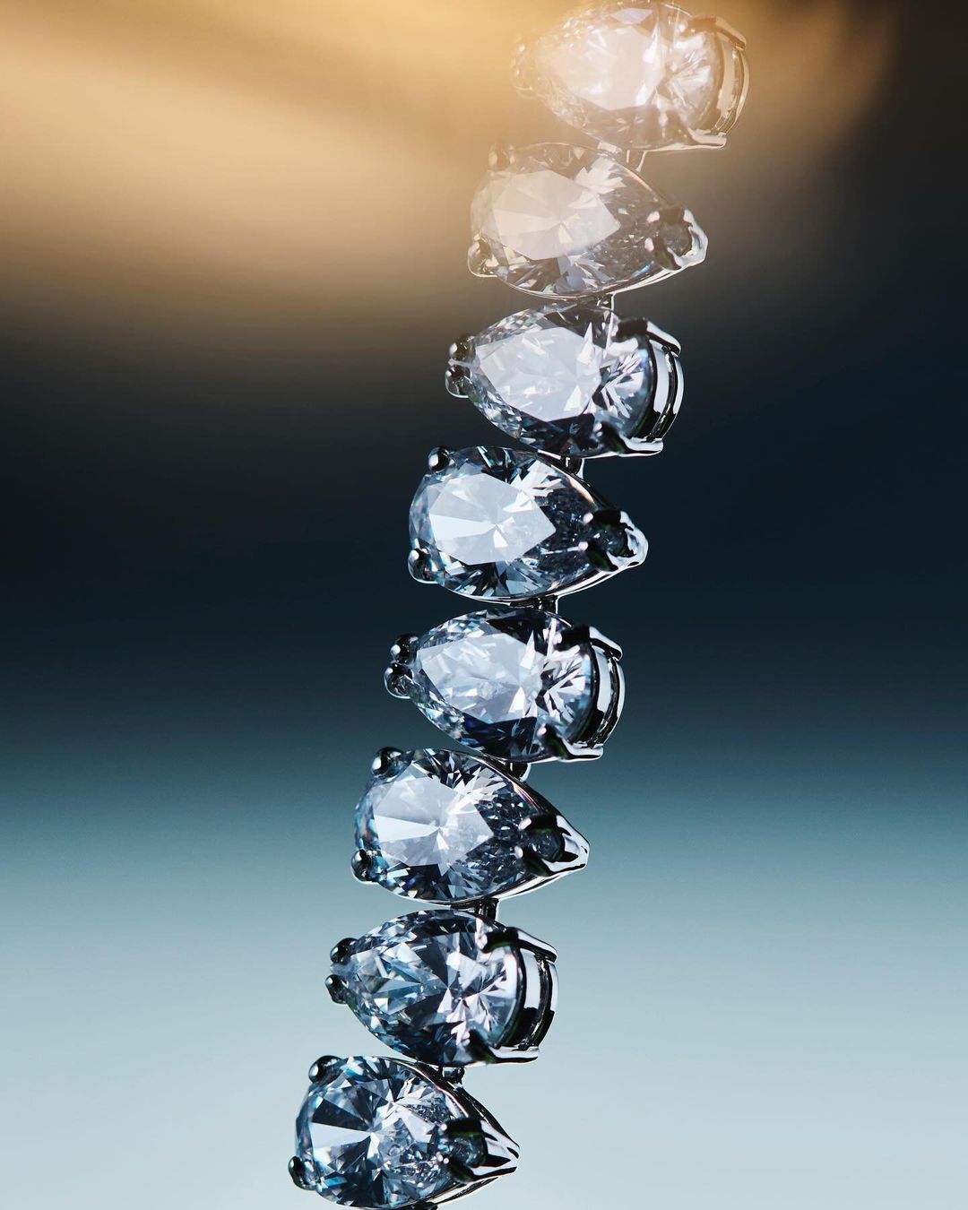 Close-up shot of diamonds in a vertical arrangement on a blue gradient background, perfect for jewelry and fashion visuals.