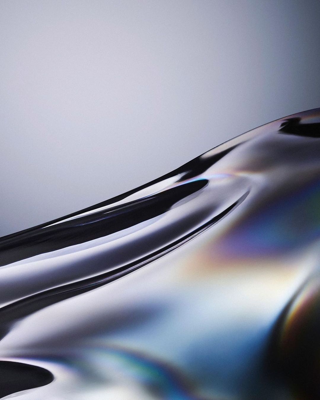 Abstract close-up of a curved, reflective surface with iridescence against a gradient grey background, creating a modern and artistic visual.