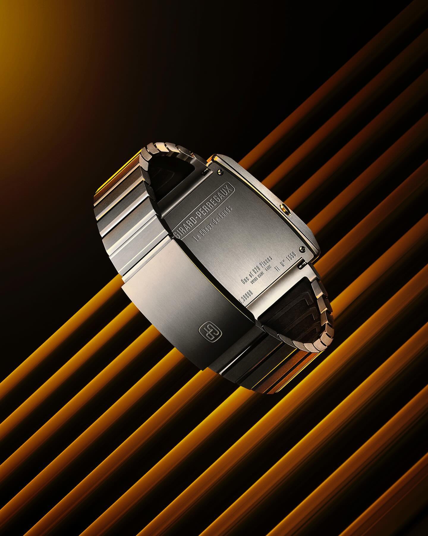 Elevated, detailed product shot of a Girard-Perregaux watch with a silver metal band, against a striped, amber-lit background.