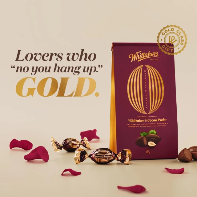 Whittaker's Cocoa Pods box surrounded by chocolate candies and rose petals, product shot for Valentine's Day gifting concept.