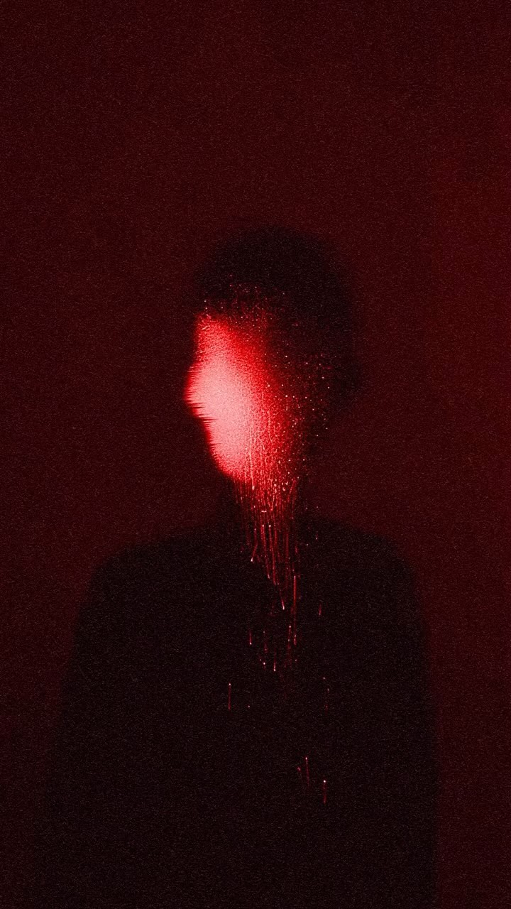Monochromatic portrait of a person's face and upper body silhouetted with a vibrant red light casting stark contrasts and dripping effect.