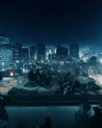 City skyline at night featuring modern buildings with illuminated windows, creating a striking urban cityscape under a dark sky.