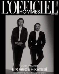 Two men in formal tuxedos posing against a light background for a magazine cover by photographer Zeynep Özkanca