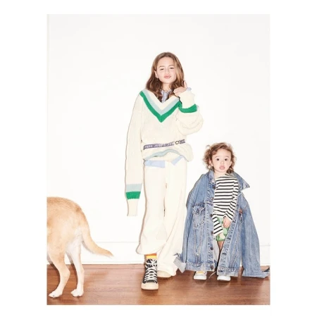 Two children and a golden dog against a plain white wall, photographed by Zoe Adlersberg in New York.