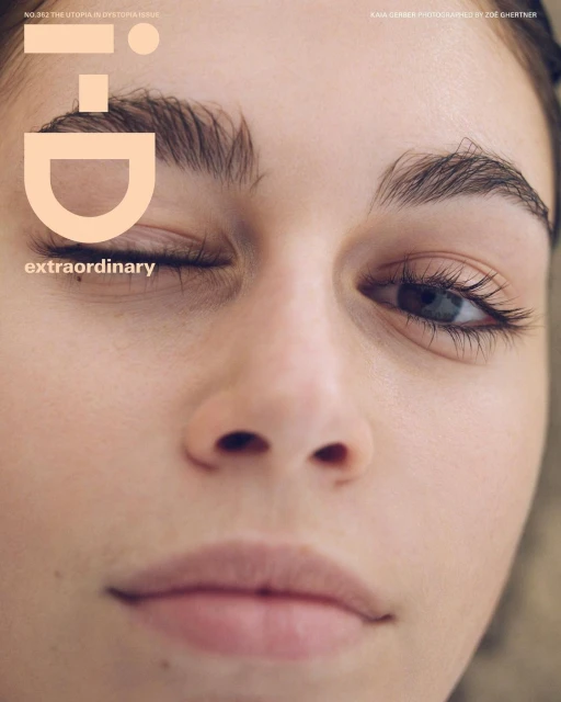 Close-up studio portrait of a fair-skinned young woman with makeup; one eye closed and looking at the camera; 'i-D' magazine cover.