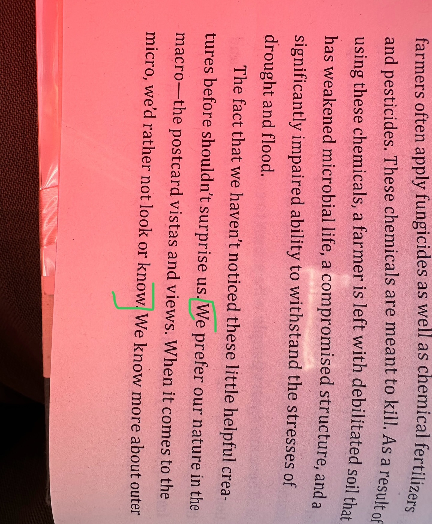 Open book page with text discussing chemical fertilizers, drought, and nature, with green bracketed areas of interest on the left side.