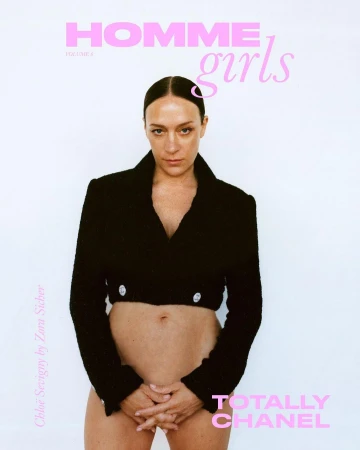 A woman poses for a magazine cover, wearing a cropped jacket and standing against a white backdrop with pink text overlay.