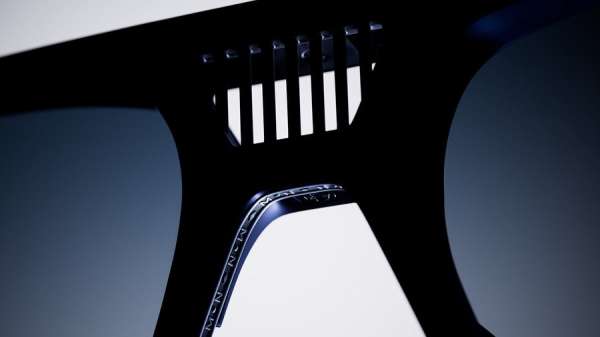 Close-up studio shot of an adjustable wrench made of black metal, featuring a toothed rack and blue accents.