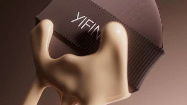 Close-up of beige foundation spilling onto the side of a textured brown makeup box with the brand name YIFIN in white lettering.