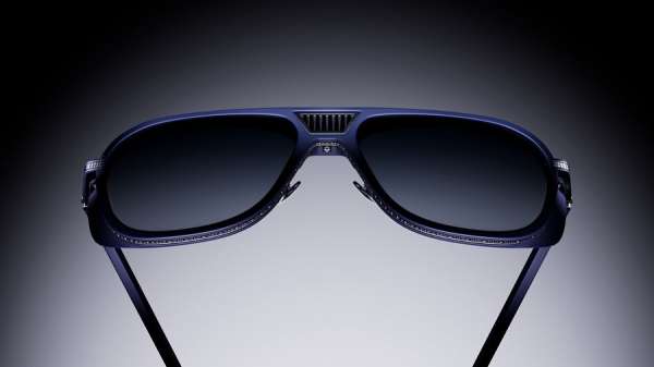Stylish aviator sunglasses with dark lenses and blue frames are centered against a graduated gray background, sleek and modern.