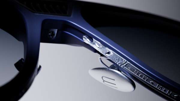 Macro shot of designer eyeglasses with blue frames, silver accents, and intricate detailing. Close-up emphasizes sleek eyewear design and materials.
