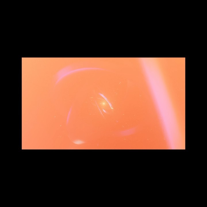 Abstract blurred background with orange color and a bright light in the center, creating a dynamic and textured visual effect.