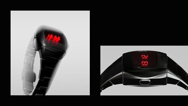 Close-up of a sleek black wristwatch with a red digital display, showcasing a modern design on a light grey and black background.