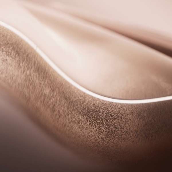Close-up abstract of soft, flowing waves of copper-toned fabric texture with subtle highlights, conveying elegance and warmth.