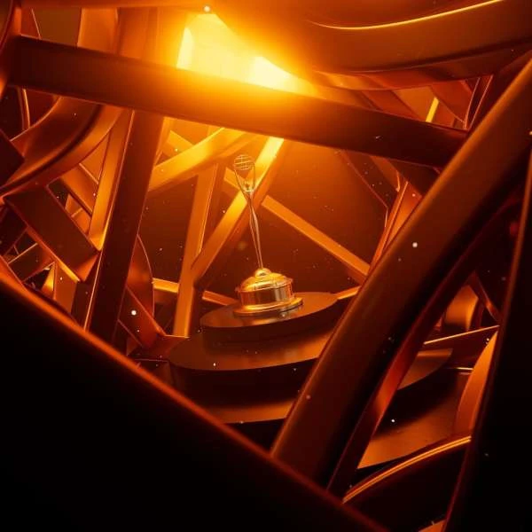 A metallic gold-colored award sits on a round platform, surrounded by angular, tubular structures, creating a complex, geometric presentation.