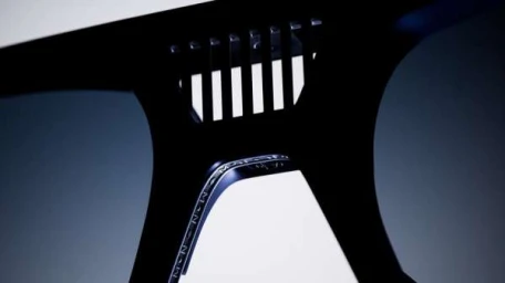 Close up abstract view of sleek black automotive or mechanical carbon fibre component with ventilation grille by Verso Studio