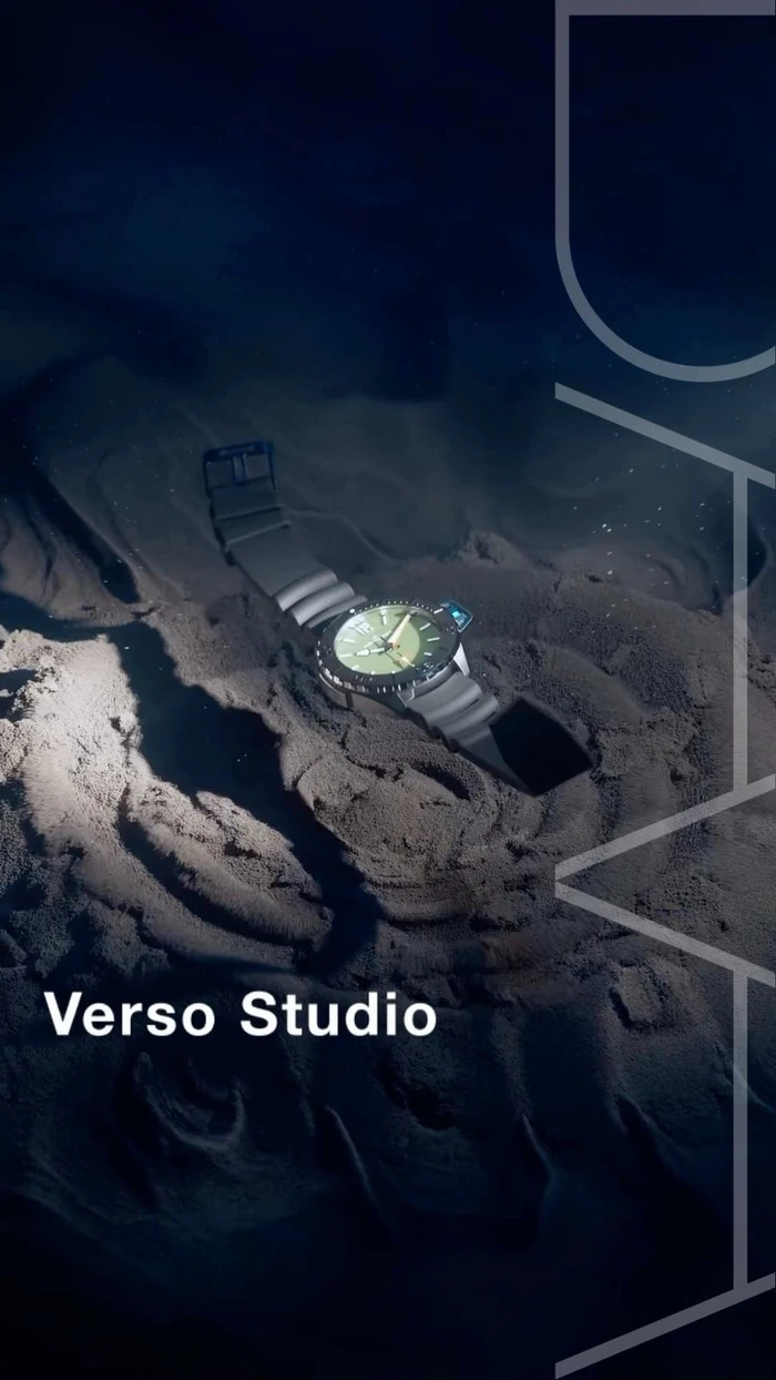A dark watch with a green dial resting on dark textured sand under a spotlight, created by Verso Studio