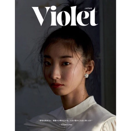 Close-up portrait of an East Asian woman wearing a white pleated high-collar top and floral earrings, shot by Vanina Sorrenti.