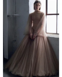 Model in a sheer tulle gown standing near a window in a room shot by Vanina Sorrenti