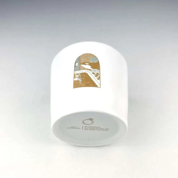 White cylindrical container with a landscape illustration and text at the bottom, set against a plain white backdrop.