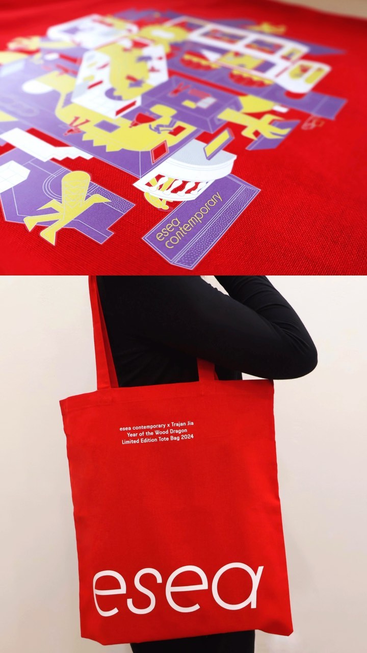 A red tote bag with the logo 'esea' in white is held by a person wearing black, with a colorful design on a red background above.