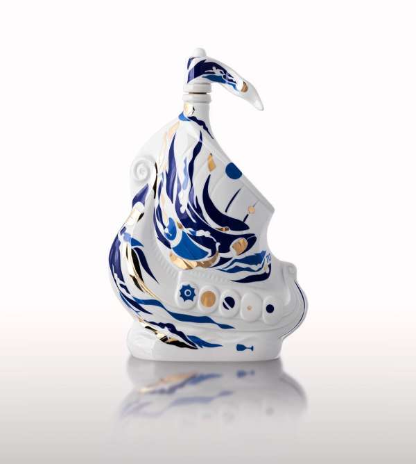 Decorative white porcelain ship with blue and gold accents, glossy finish, studio lighting, displayed on a reflective white surface.