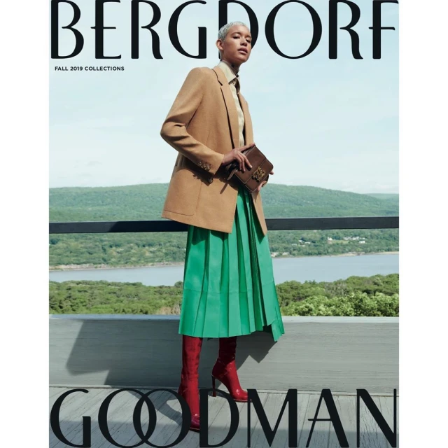 Magazine cover featuring a model in a tan blazer, green pleated skirt, and red boots, standing against a scenic outdoor background.