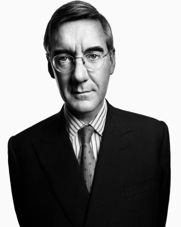 Portrait of Jacob Rees-Mogg wearing glasses, striped shirt, patterned tie, and a dark suit against a plain white background