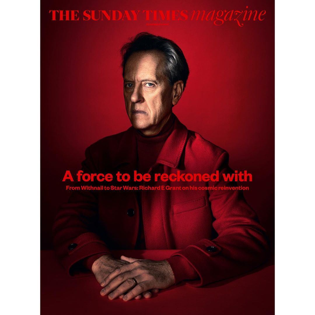 Portrait of Richard E. Grant on a red background for The Sunday Times Magazine, featuring the headline 'A force to be reckoned with'.