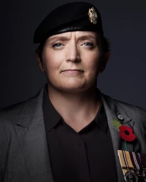 Portrait of a woman wearing a black beret and grey blazer with military medals pinned to the lapel, photographed by Stuart Mcclymont.