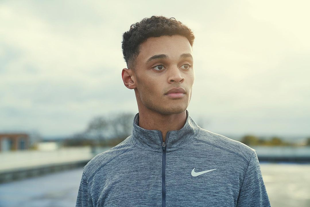 Portrait of a young adult man in athletic wear, looking off into the distance. Outdoor daytime shot of an athletic male.