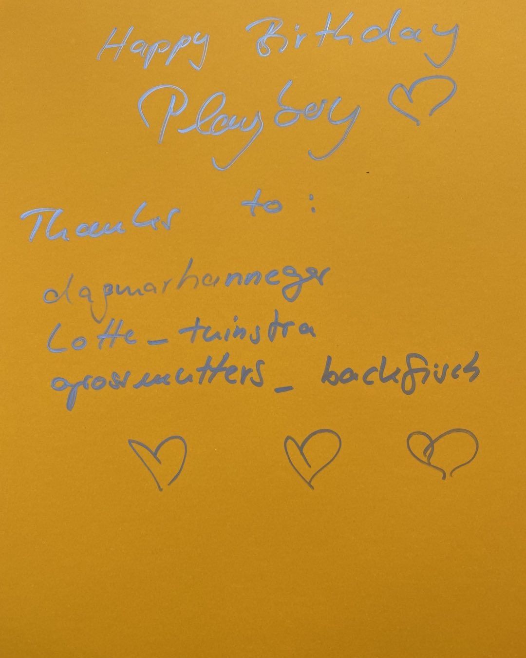 Handwritten message on bright orange background including words like 'Happy Birthday' and 'Playboy' along with other text.