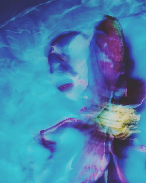 Abstract portrait of a person in motion, with blurred features and a dreamlike effect, set against a vibrant turquoise background.