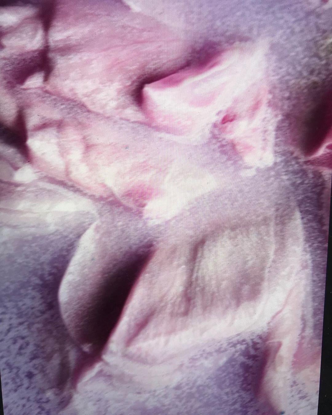 Close-up of pale pink flower petals with soft light and blurred background, highlighting delicate texture and subtle gradients in color.