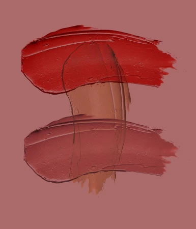 Abstract beauty shot of lipstick swatches in red and pink hues on a matching pink background, showcasing texture and color for beauty advertising.