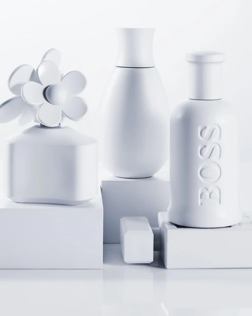 Still life arrangement featuring three different white perfume bottles displayed on small white platforms against a stark white backdrop. 