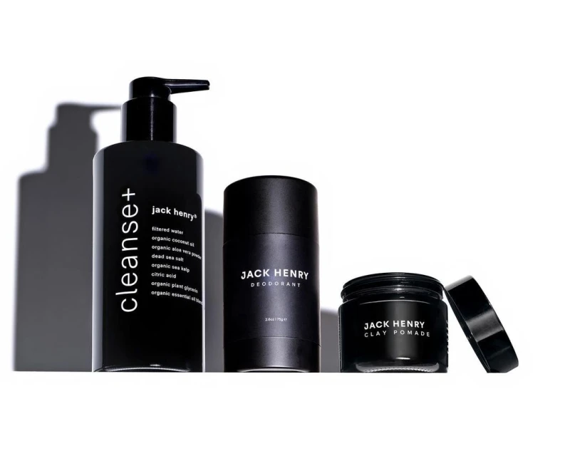 A trio of Jack Henry men's grooming products in black bottles against a bright white background, including cleanser, deodorant, and clay pomade.