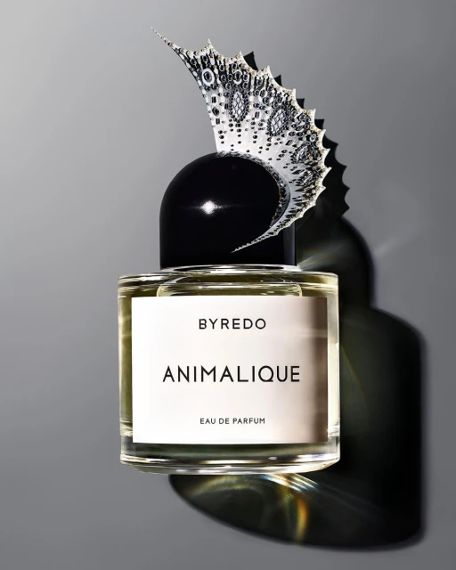 Studio shot of Byredo Animalique Eau de Parfum bottle with decorative butterfly element on grey background, perfume, cosmetics, beauty.