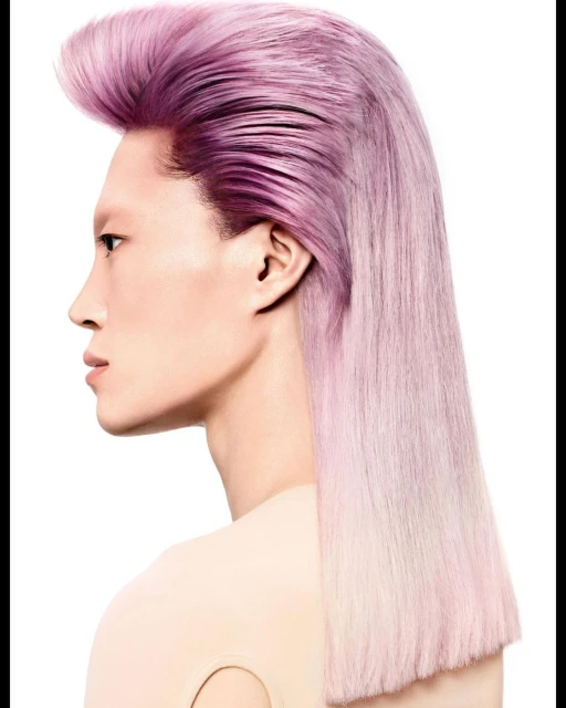 Profile portrait of an adult with long straight pink and purple dyed hair and a light complexion, styled in a modern pompadour.