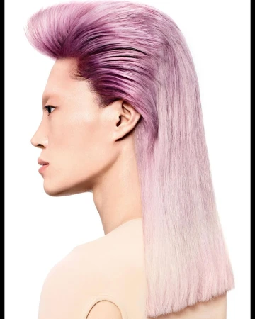 Profile portrait of an adult with long straight pink and purple dyed hair and a light complexion, styled in a modern pompadour.