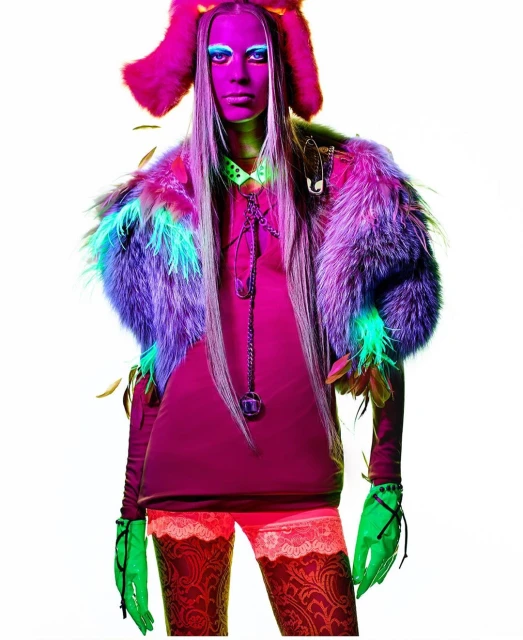 A woman with long blonde hair poses in bright, colorful, high-fashion outfit in a studio setting with a white background, fashion photography.