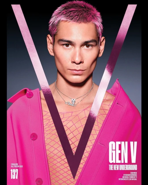 Magazine cover featuring a fair-skinned person with pink hair, wearing a pink jacket, against a dark background with a large 'V' graphic.