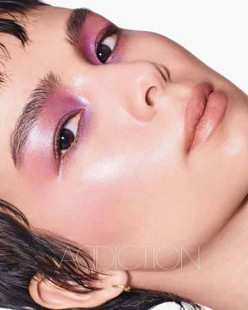 Close-up beauty portrait of a model with glossy purple eyeshadow and luminous skin by Richard Burbridge