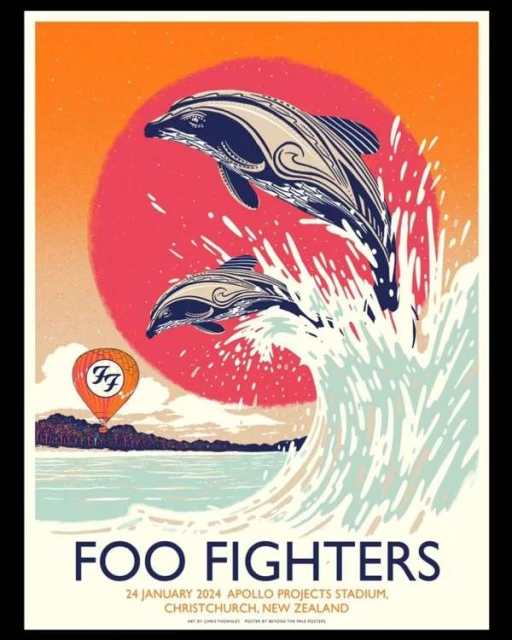 Poster art featuring two dolphins leaping from ocean waves, against a sun and coastal background with a hot air balloon.