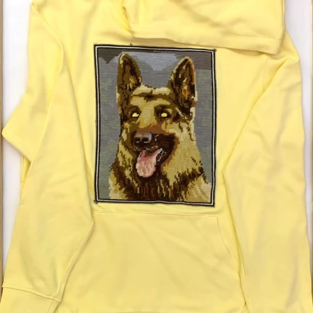 Yellow hoodie featuring a tapestry of a German Shepherd dog, showcasing detailed stitchwork and a unique apparel design with canine theme.