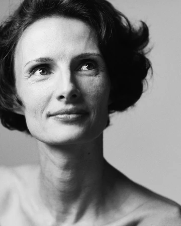 Monochrome portrait of a woman with short dark hair looking upward against a plain light background