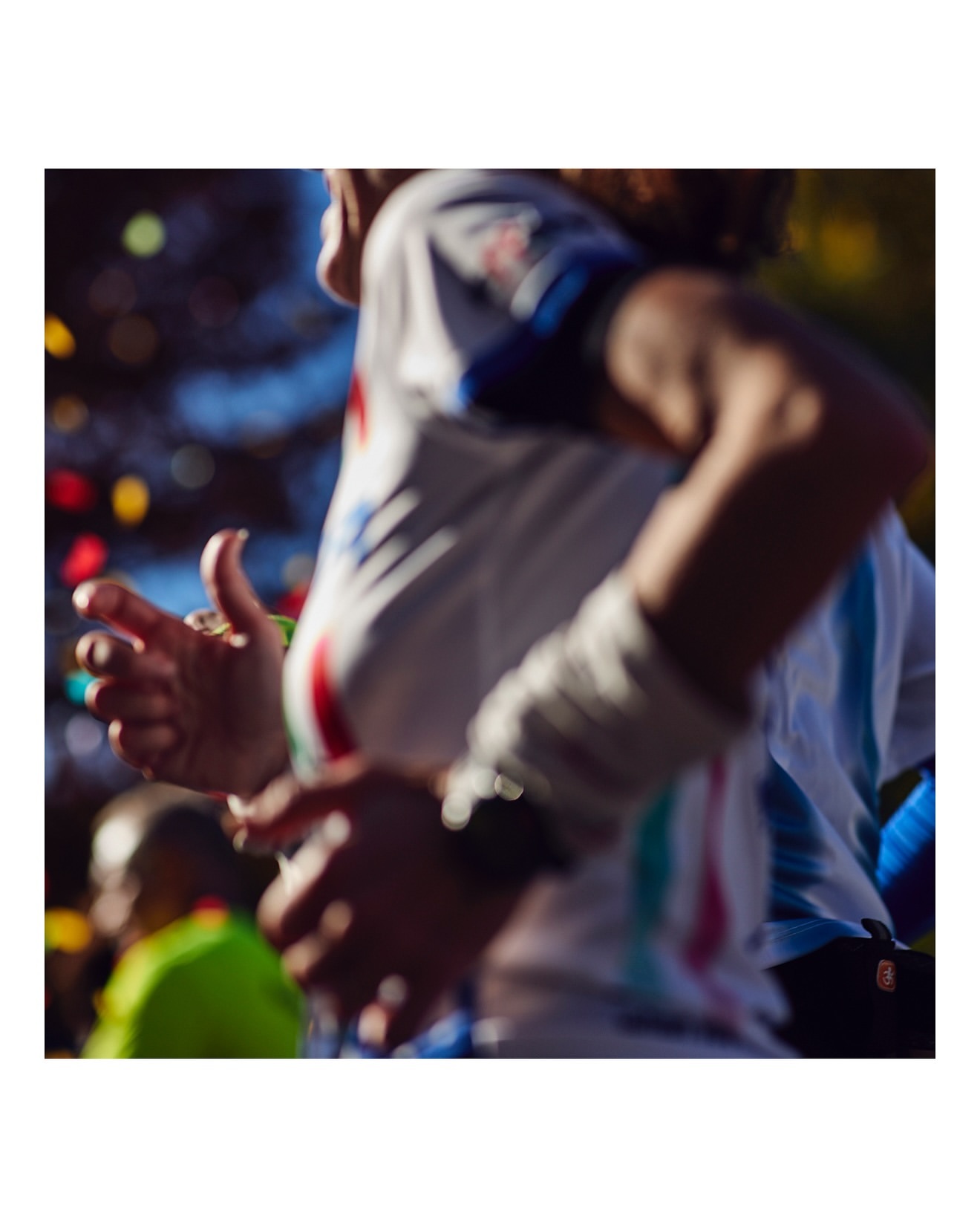 Close-up of people participating in a race, with blurred background lights, action-oriented shot, capturing the energy of the event.