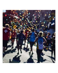 A group of runners participating in a street marathon surrounded by blurred colorful confetti bokeh.