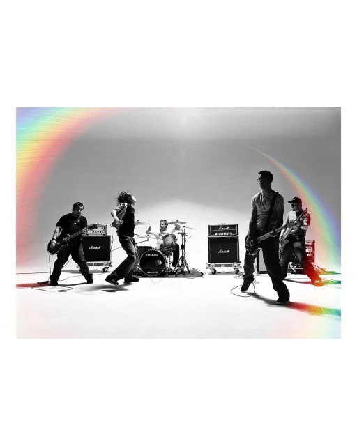 A band of five members performs on a white stage with music equipment. The members play instruments and stand under bright, even lighting.